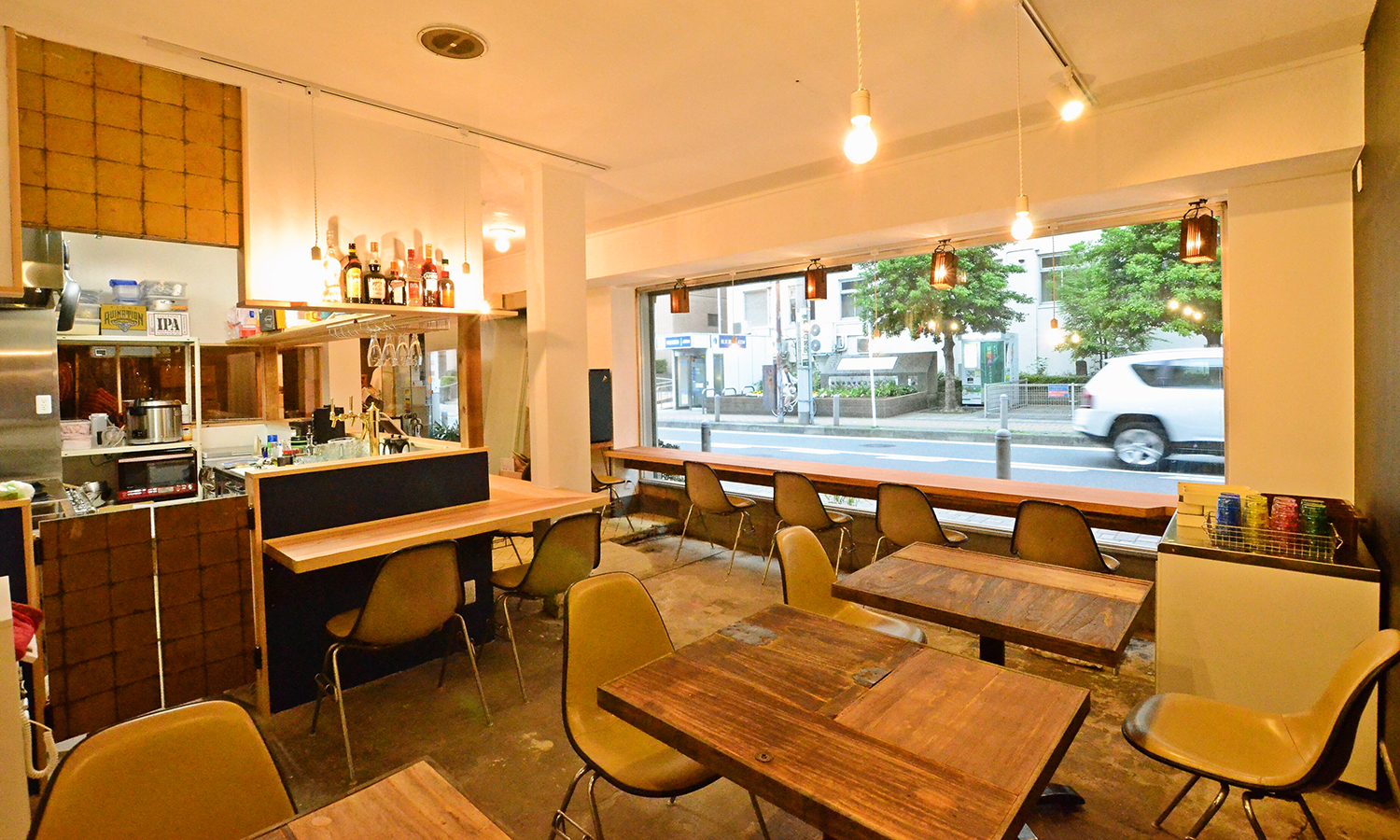 大きな窓と木のテーブルが並ぶ、マルニカフェの店内